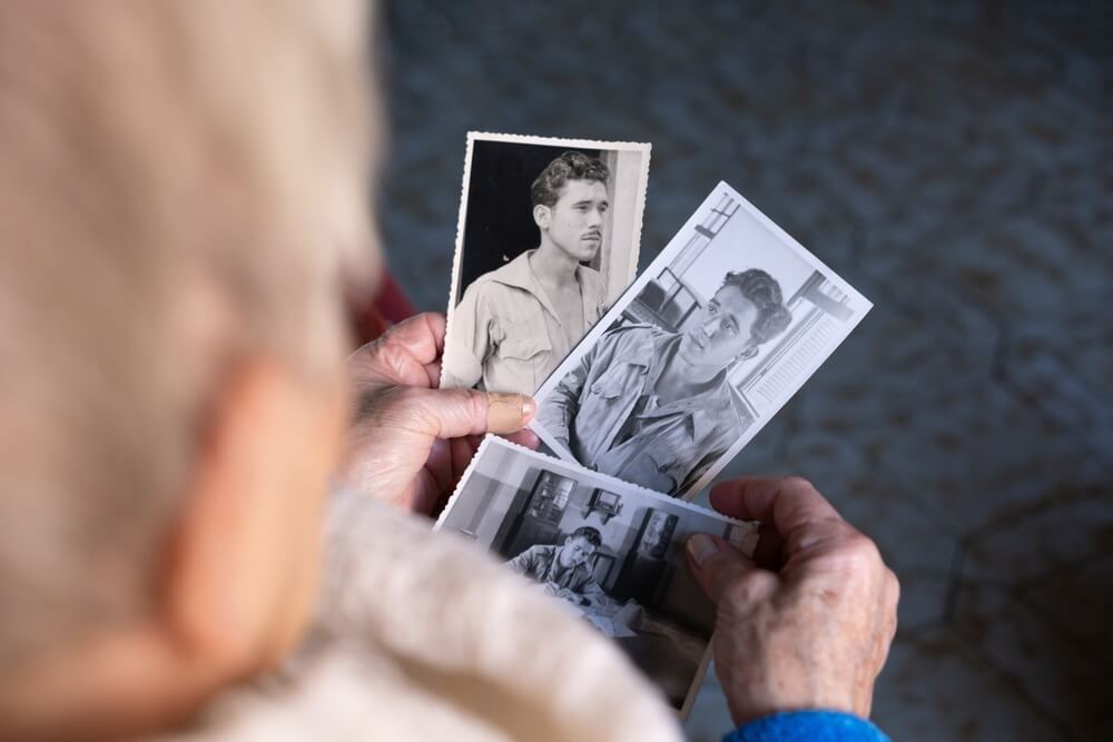 옛날에 젊었던 본인의 사진을 보고 있는 할아버지