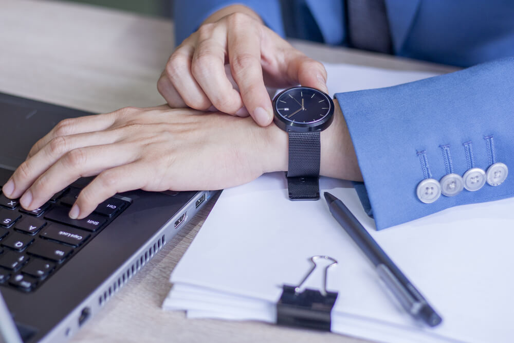 칼퇴하기 위해서 사무실에서 시계를 보는 남성