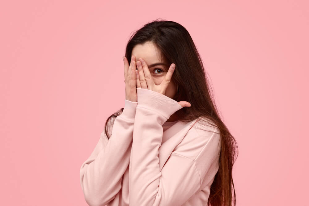 창피한 듯 얼굴을 가리고 있는 여성