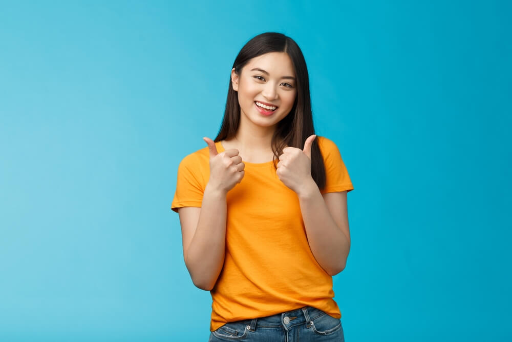 찬성하는 의미로 엄지를 들어 보이는 여성의 모습