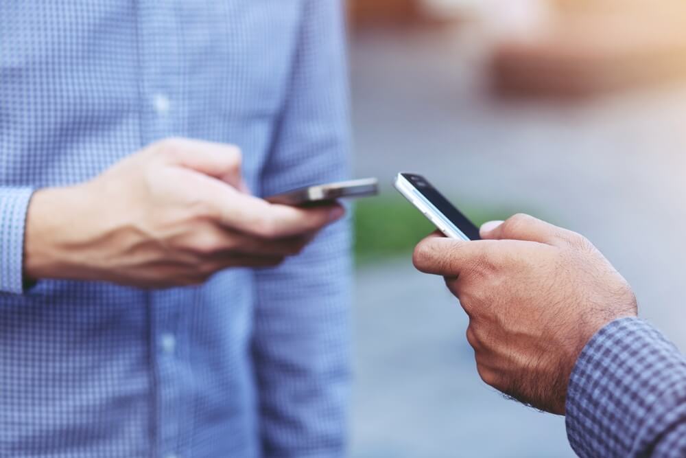 핸드폰 번호를 교환하고 있는 두 사람