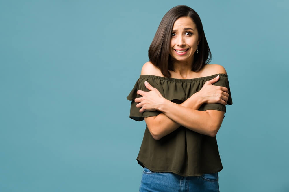 소름이 돋아 두 팔로 몸을 감싼 여자
