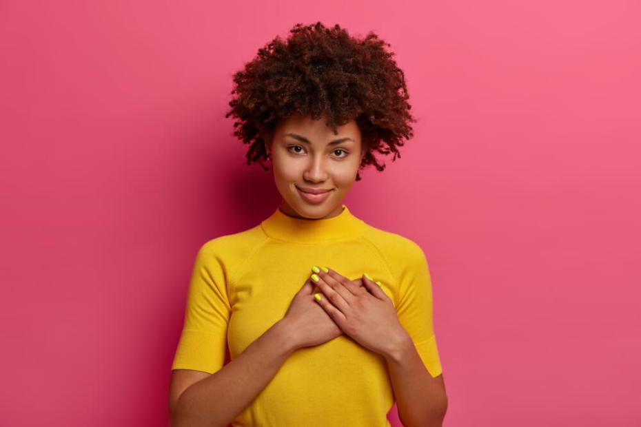 감사하는 마음으로 가슴에 손을 얹고 있는 여성