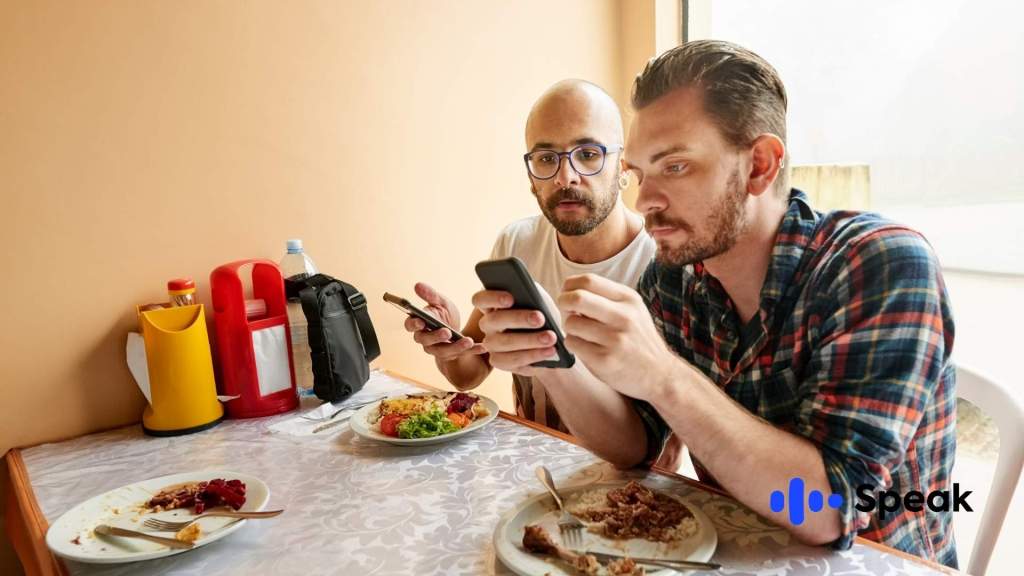 Dos hombres disfrutando de la aplicación Speak después de visitar la página de descarga.