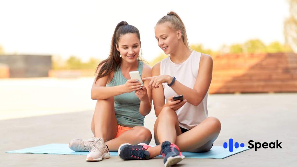 Dos chicas emocionadas viendo cómo descargar Speak en sus dispositivos.