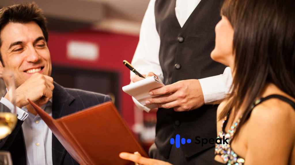 Mesero y pareja pidiendo comida en un restaurante
